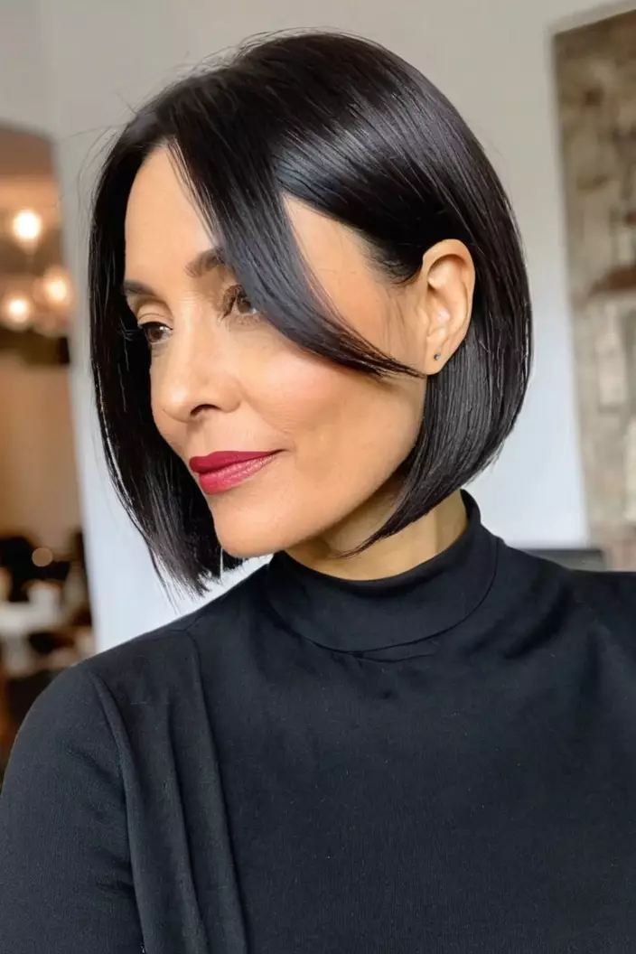 A photo of a 41-year-old Patricia, blunt asymmetrical bob for thick hair, living room background  