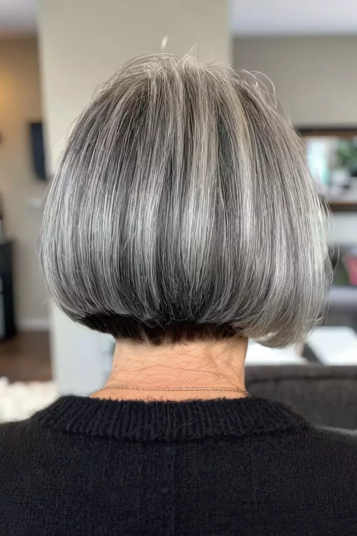 A photo of a 63-year-old Jessica, salt and pepper bob with fine hair, back view, living room background  