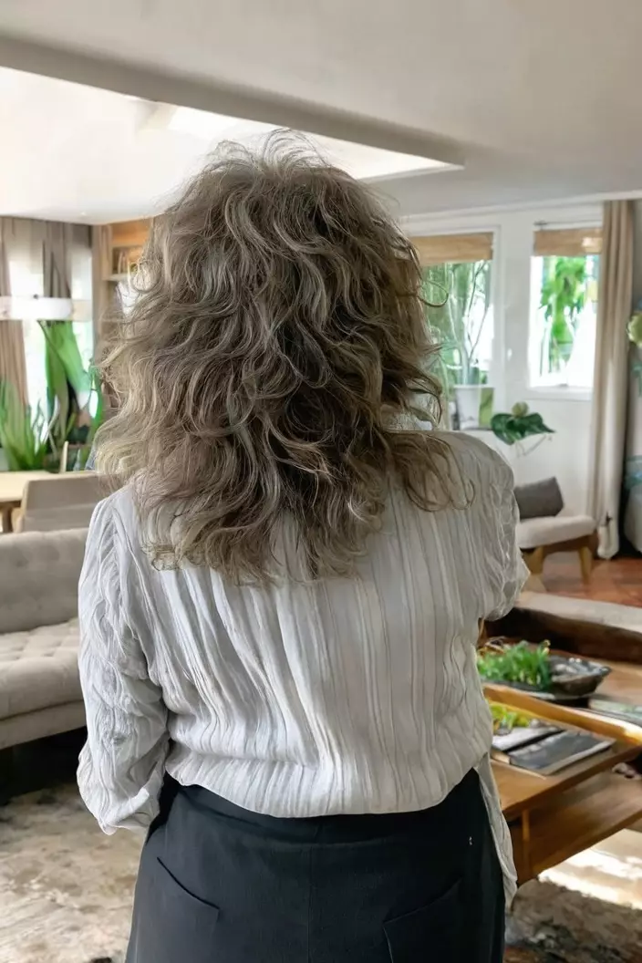 Wavy Shaggy Layers A photo of a 67-year-old Linda, wavy shaggy layers, back view, living room background
