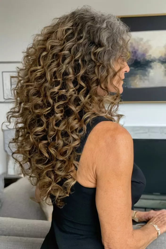 A photo of a 58-year-old Lorraine, Natural Shoulder-Length Curls, back view, living room background  