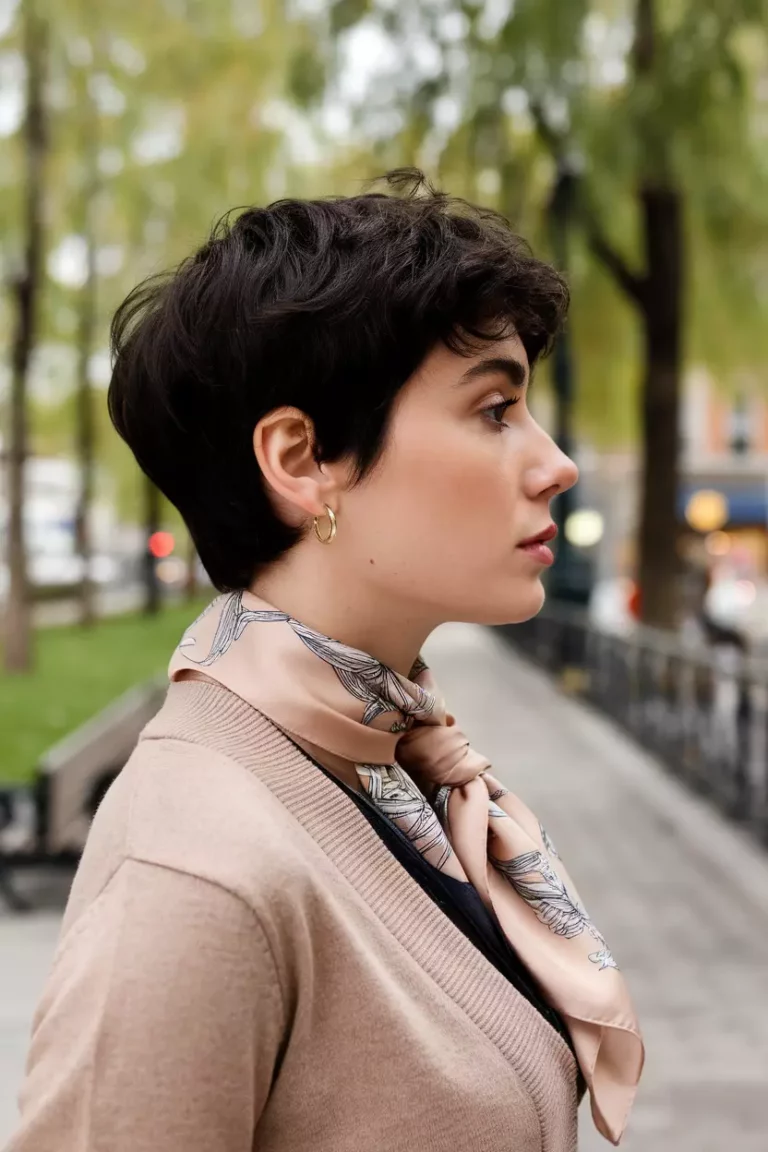 A beautiful woman with a natural black pixie cut hairstyle, side view, city park background