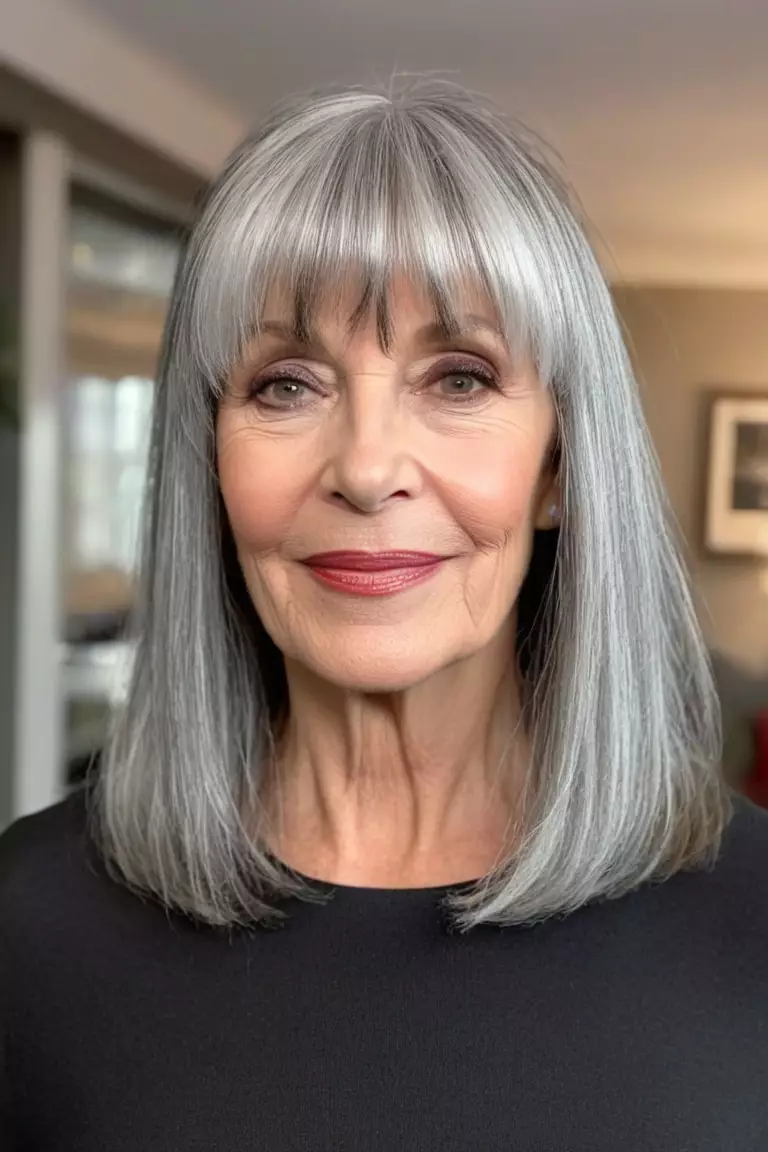 A photo of a 61-year-old Pamela, with a silver lob with face-framing bangs hairstyle, Front view, living room background