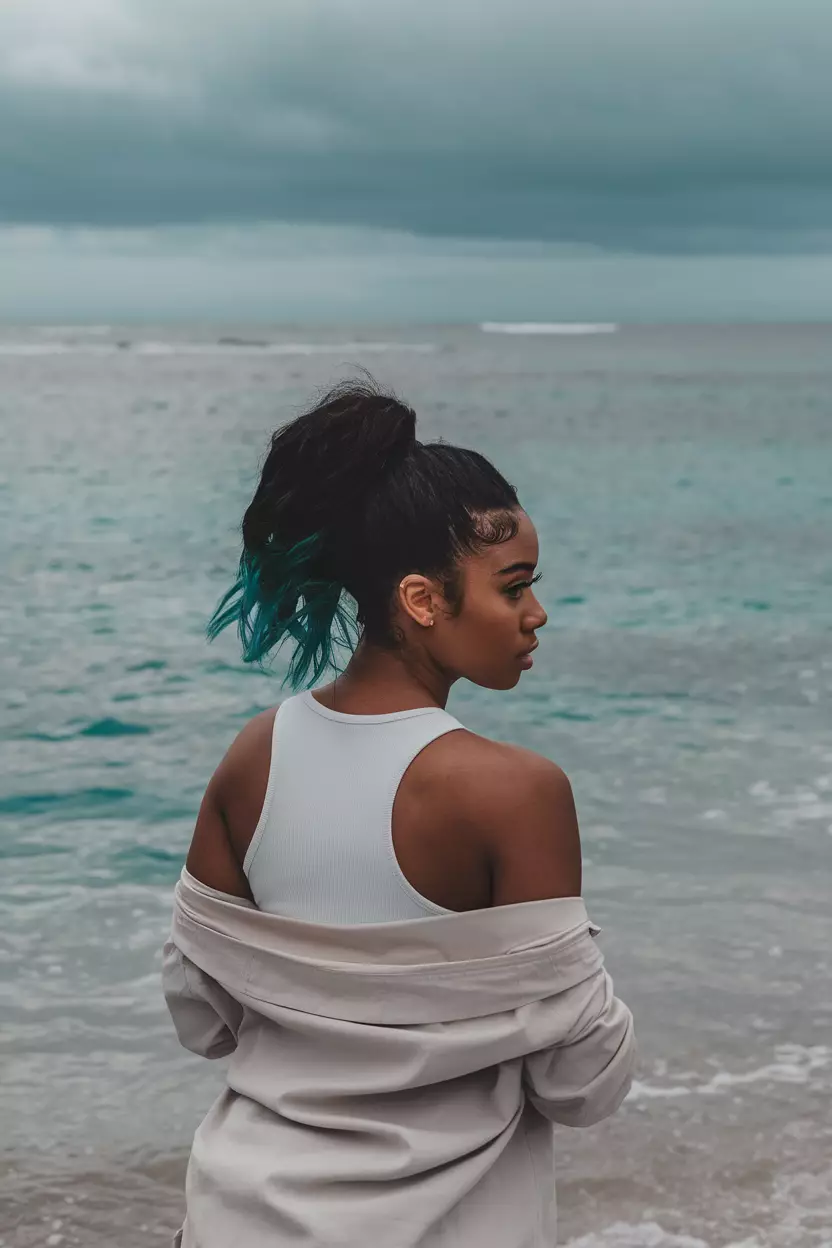 Teal Tips Ponytail A beautiful black woman with dark hair in a high ponytail showing off teal tips, back view, clear blue ocean background