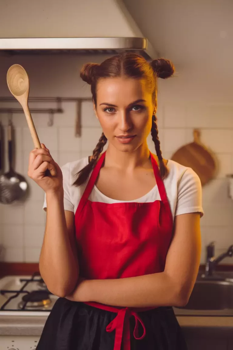 A beautiful woman with grown up pigtails, kitchen background