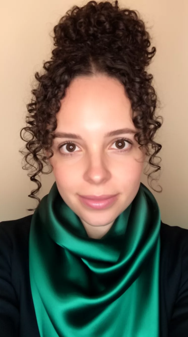 selfie of a 33-year-old woman wearing a deep emerald green silky scarf with a Low curly bun with loose front tendrils