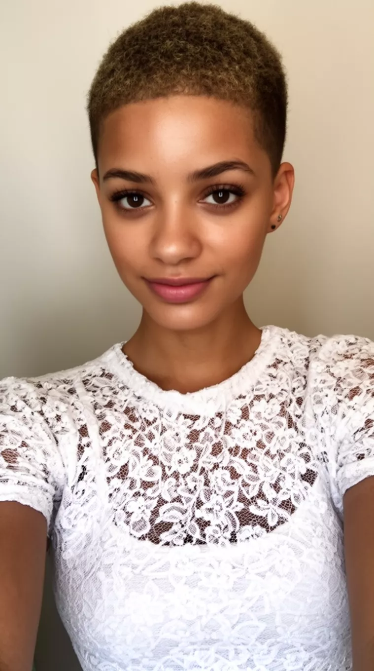 selfie of a 23-year-old woman wearing a white lace top with a Textured Crop Cut hairstyle, minimal background