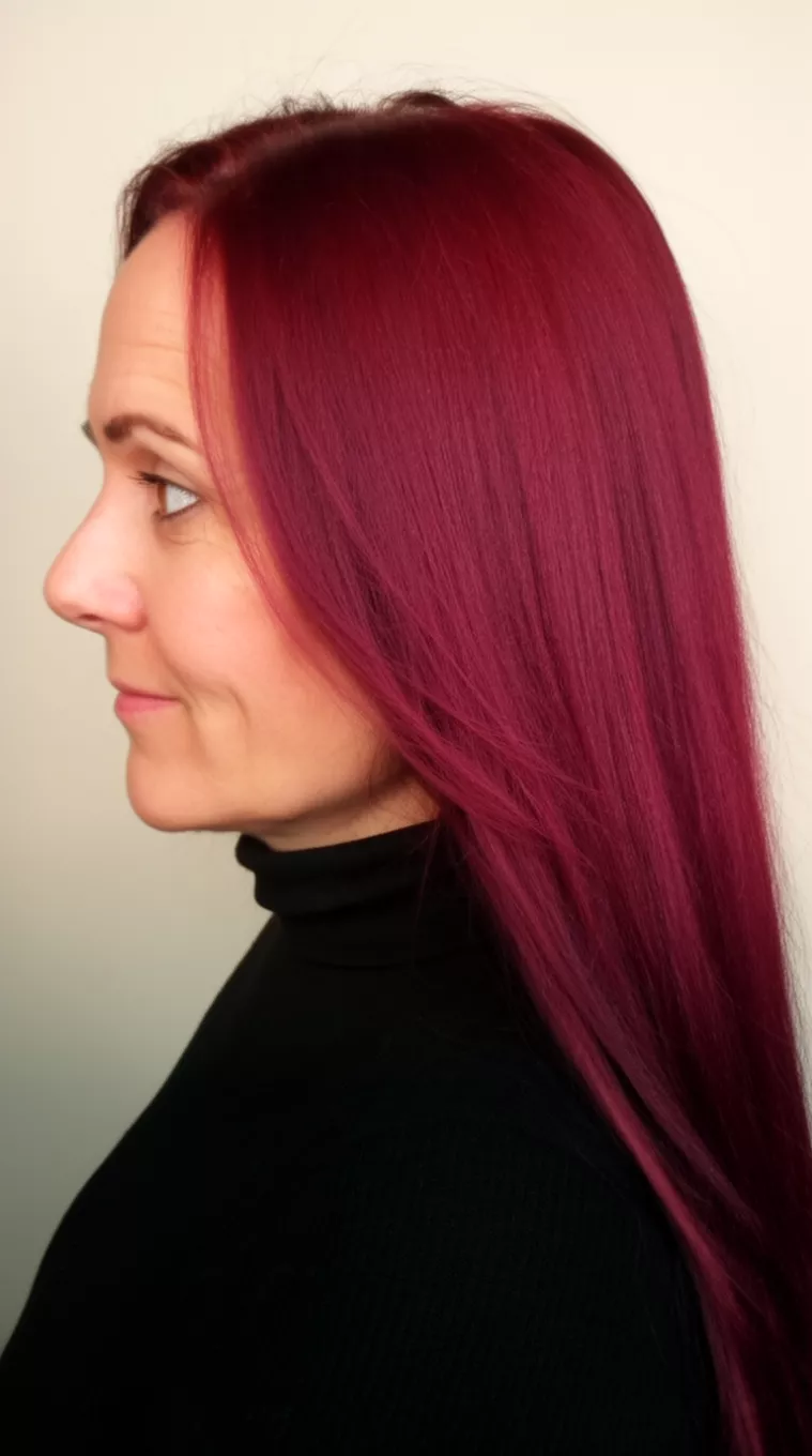[close-up photo (side view)] of a 42-year-old woman wearing a black turtleneck with a Merlot Mystery Shades colored long hairstyle, minimal background, [side view]