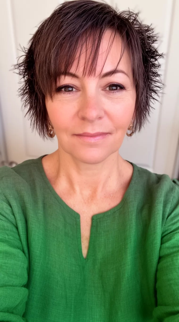 selfie of a 45-year-old woman wearing a forest green linen top with a Fringy Pixie hairstyle