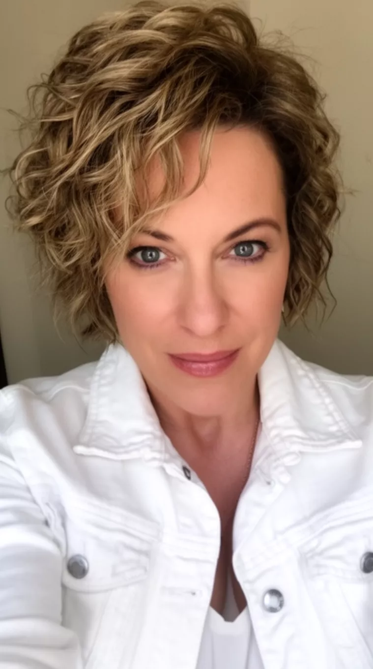 selfie of a 37-year-old woman wearing a white denim jacket with a Textured Layers hairstyle