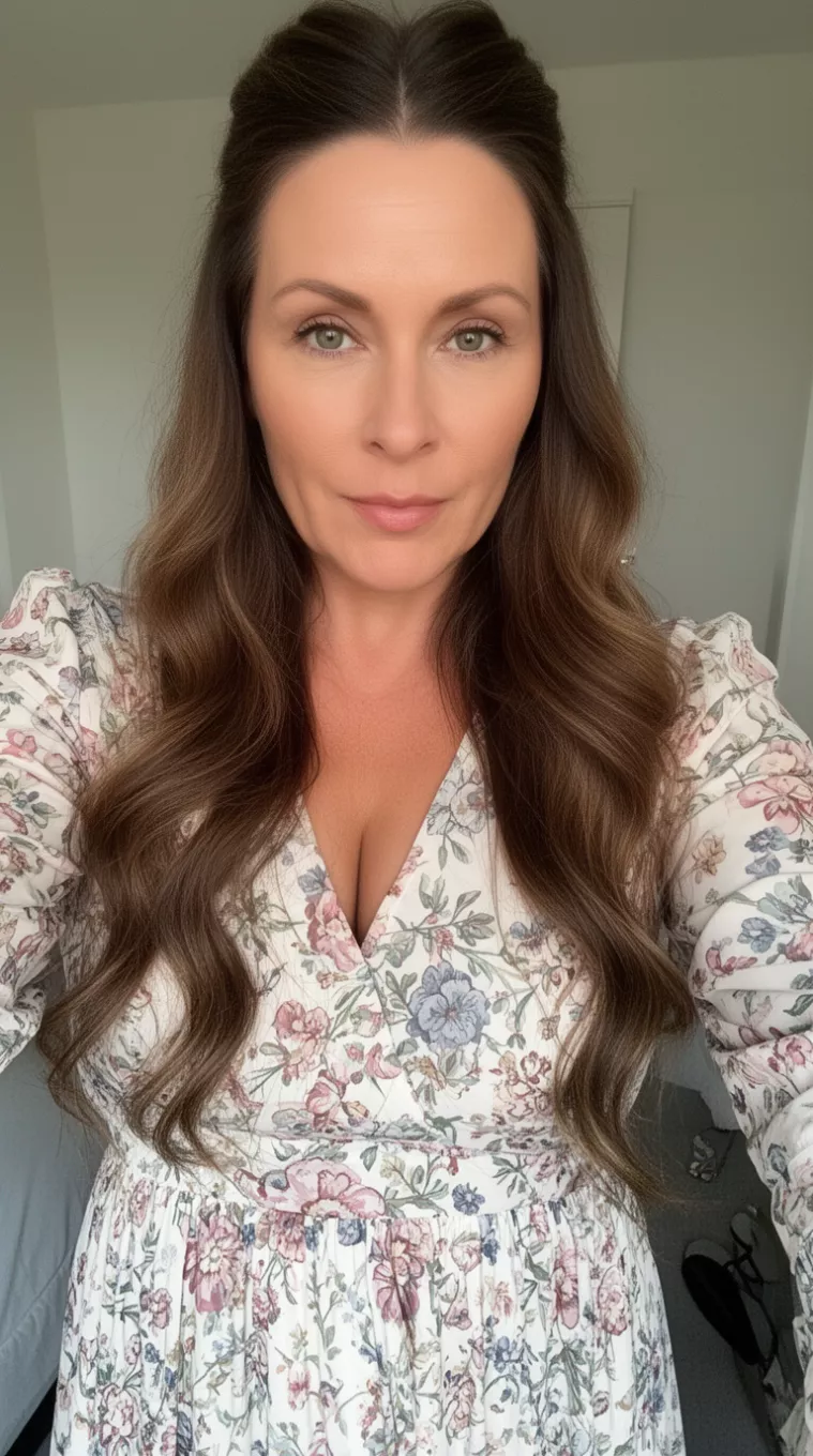 selfie of a 39-year-old woman wearing a floral maxi dress with a Half Up Half Down hairstyle, minimal background