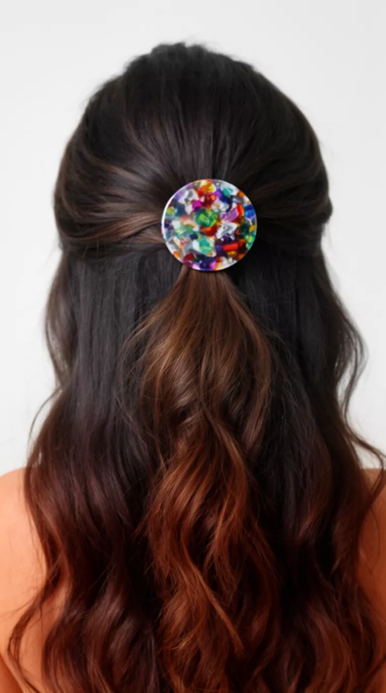 casual close-up photo of a 30-year-old woman with long dark brown wavy hair styled half-up and secured with a colorful patterned round acrylic hair clip, back view, minimal background
