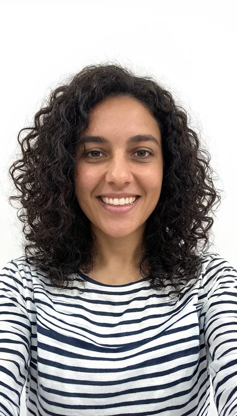 Curly Frame For Natural Beauty selfie of a 28-year-old woman wearing a striped shirt with a dark, curly medium length hairstyle framing her face, front view, white background